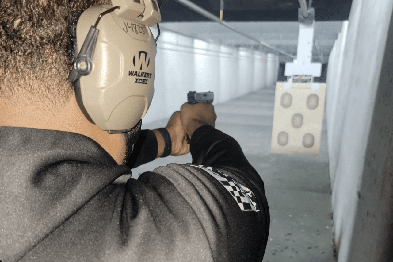 Basic firearms student practicing handgun fundamentals at an indoor range