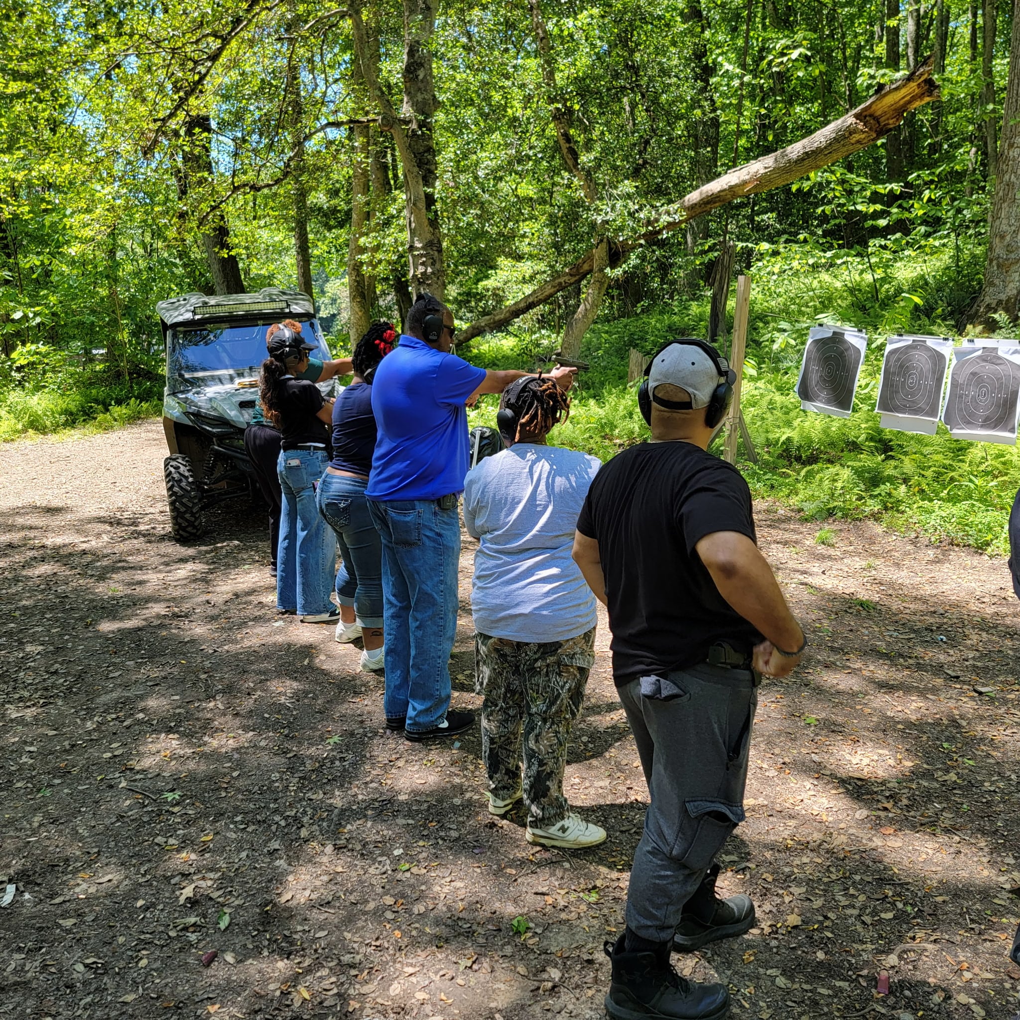 Instructor coaching students during live-fire practice at the outdoor range