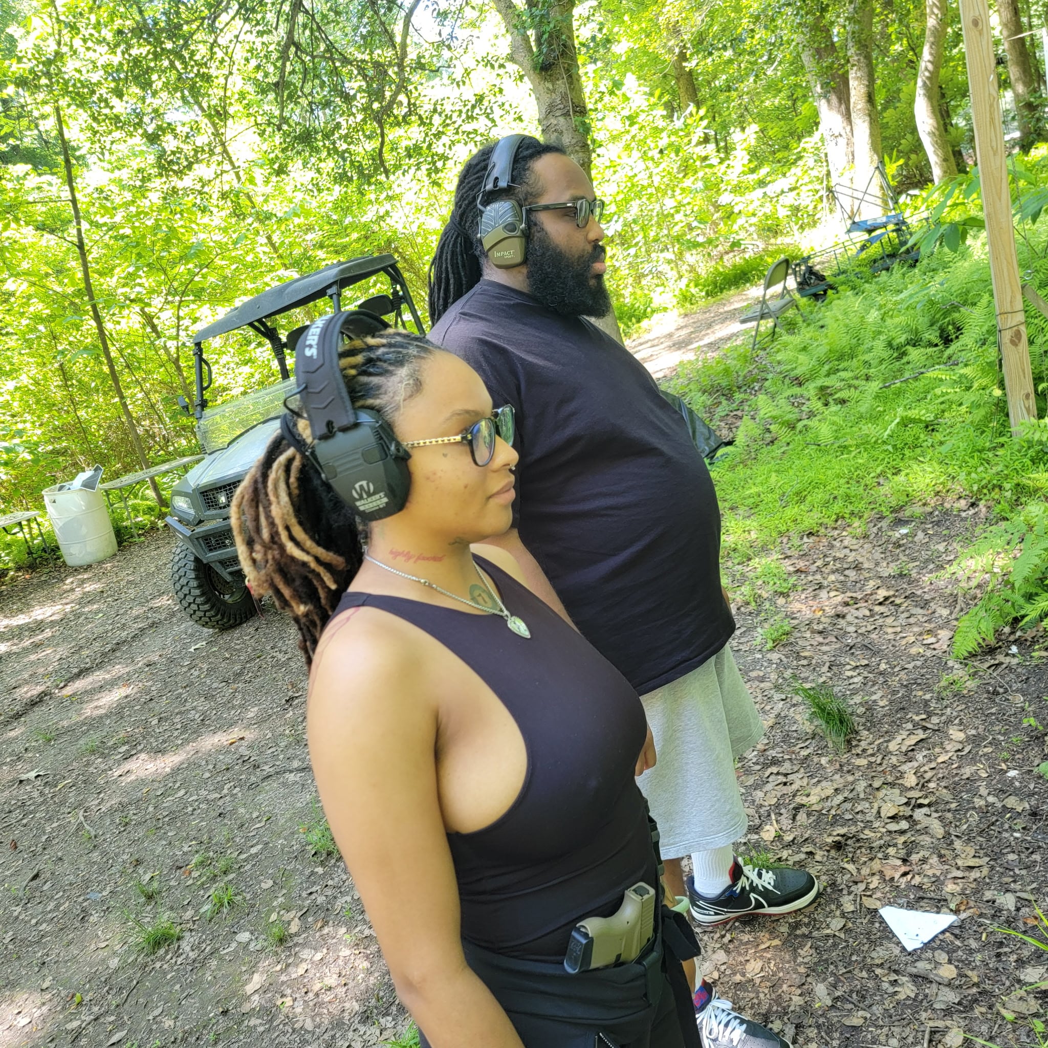 Two students wearing eye and ear protection while preparing at the range